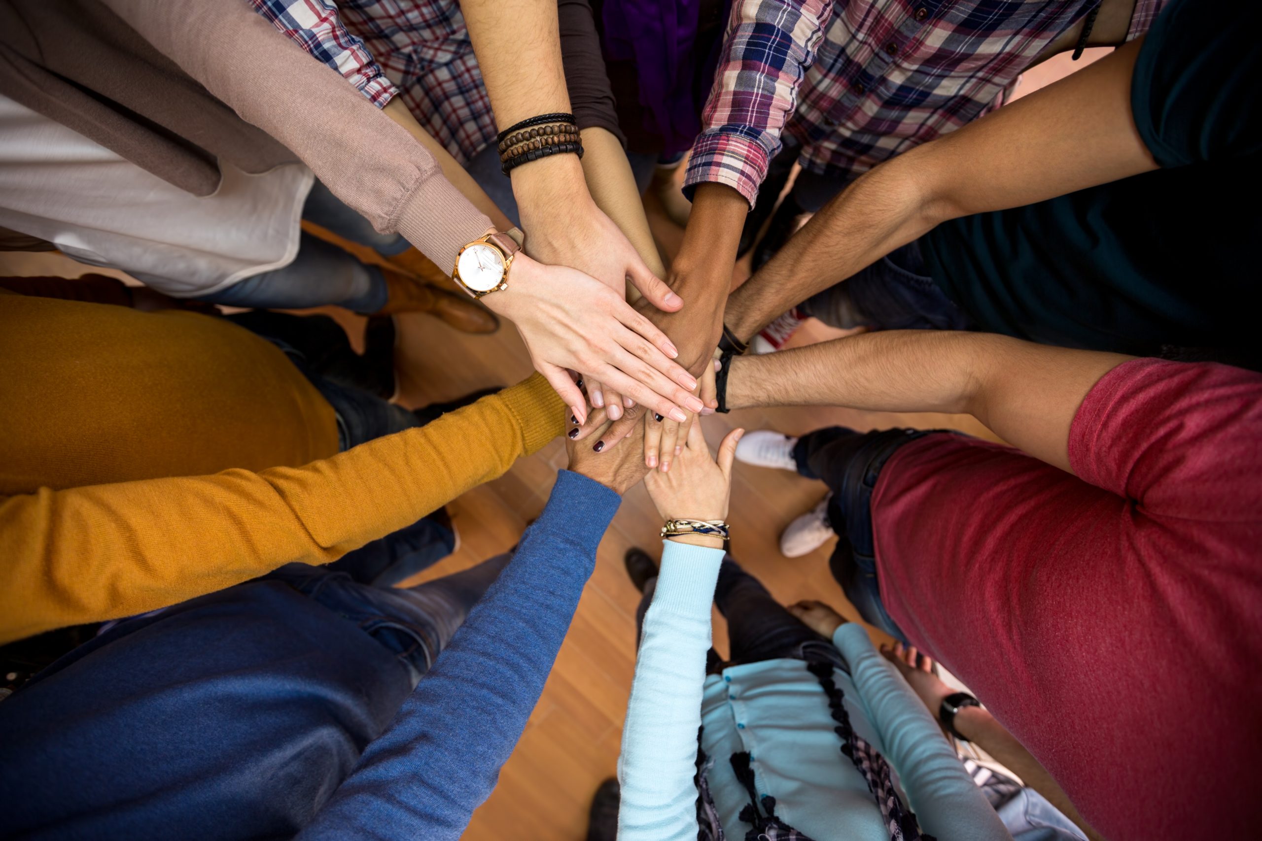 many hands put together in a circle